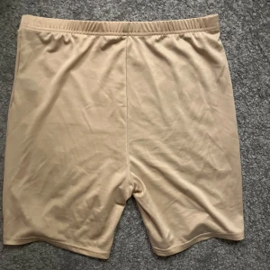 Beigea hotpants - Beigea hotpants att ha under klänning eller kjol. Säljes för att jag aldrig använder de. Köpta från SHEIN i storlek L. Jätteskönt material.