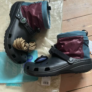 Crocs Nicole McLaughlin - Säljer ett par Crocs x Nicole McLaughlin Campsite Crocs, helt oanvända. De är jävligt coola och perfekt till dig som vill ha något unikt. Priset är diskuterbart och det är bara att höra av dig om du har några frågor.