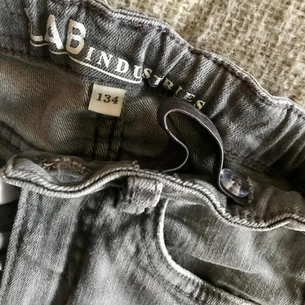 Grå bootcut jeans i strlk 134. Superfina och som nya! Tvättade en gång men inte använda, då de blev för små för fort.  Stretchiga bootcut-jeans med medelhög midja och fem fickor. Trendiga och bekväma jeans med reglerbar resår på insidan av midjan. . Jeans & Byxor.