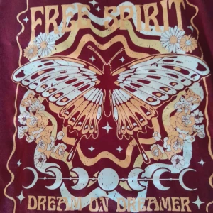 T-shirt med fint tryck - En vinröd t-shirt med ett fint tryck på framsidan. Jättemjukt och behagligt material. Storlek XS men oversize, sitter bra på mig som vanligtvis har S/M. Mycket fint skick, nästan ny.