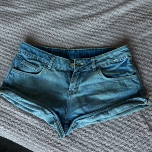 Lågmidjade jeansshorts  - Säljer dessa lågmidjade jeansshorts då de är för stora för mig. Man kan vika upp dem för att få dem kortare eller ha vanligt (se bild 3). Ingen aning om märket eller storlek då de är gamla