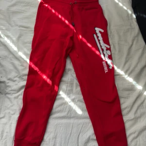 Röda Hoodrich byxor M - Fina byxor knappt använda finns inte några tecken på användning. Insydd text på sidan  Storlek: M Pris kan diskuteras vid en snabb affär!