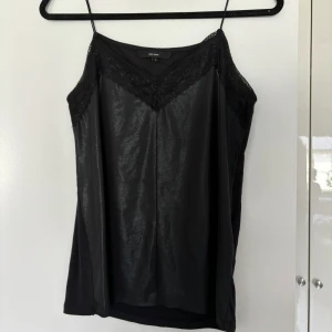 Svart linne - Svart linne med lite snarlik läderimitation på framsidan. Strechigt material och med spagetti axelband🖤✨