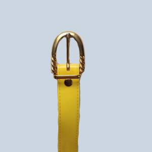 Ett gult bälte med guldsmycke som inte är använt och som är i jättebra skick!