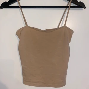 Linne - Ett Croppat linne i beige. Storlek xs.