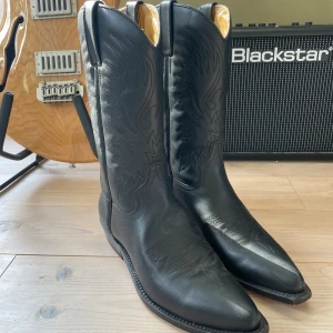 Cowboyboots - Svarta medelhöga cowboyboots från Primeboots i äkta läder. Superfin kavlite och sparsamt använda. Tecken på användning är tydligast på undersulan, se bilder.  