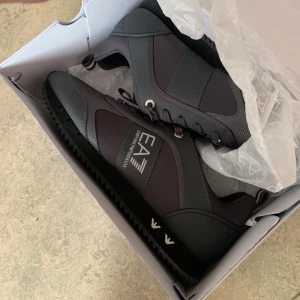 Emporio Armani skor - Helt nya, oanvända EA7 skor köpta på JD sports för ca 6 månader sedan. Säljer dem för det var verkligen inte min stil. Nypris ca 2200kr