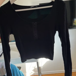 Svart långärmad topp - Super fin och skön! Knäpparna gör att du själv kqn välja hur öppet du vill ha