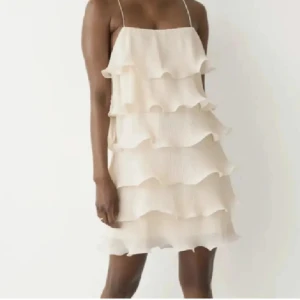 & Other Stories klänning - Säljer denna fina, slutsålda volang klänningen från & other stories. Mycket fint skick utan några defekter. Säljer då den är lite stor på mig, den är beige/ creme-vit och i M/38. 