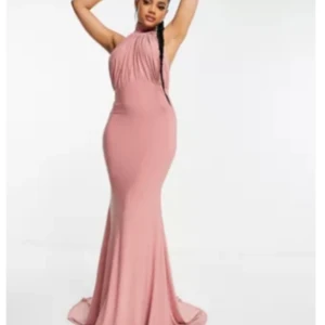 Oanvänd - Puderrosa klänning  - Oanvänd Rosa maxiklänning med halterneck, öppen rygg och släp  Röda bilderna är bara för att visa modellen på klänningen 