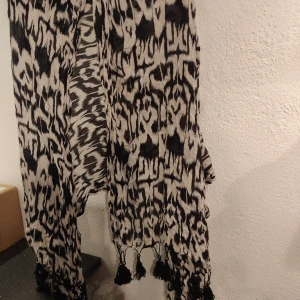 Halsduk  - Tunnt tyg med toffsar