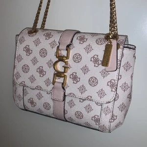 Guess väska - Säljer denna superfina väska från guess, superbra skick då jag knappt använt den Säljer pga att den aldrig kmr t användning. pris kan diskuteras🩷