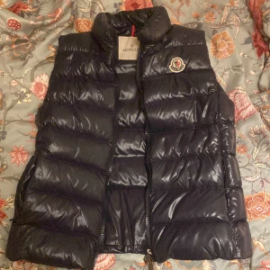 Glansig Moncler väst - Jättefin och bra skick, säljer pga att jag har växt ur den (äkta). Storlek 0. Köpt på room 1006 för 5200kr. 