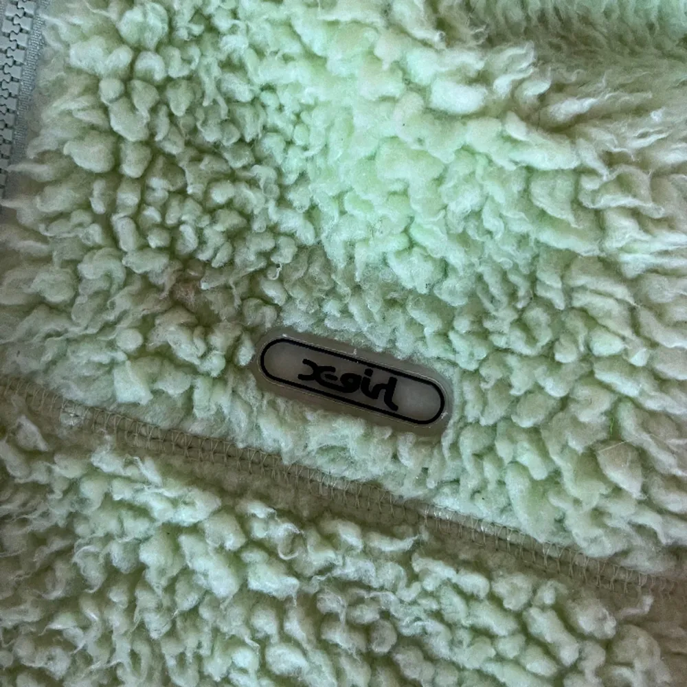 Grön fleece hoodie från X-Girl. Litet filmpmärke på ena ärmen (syns ej när tröjan är på). Annars i bra skick! . Hoodies.