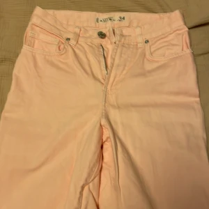 Rosa jeans - Rosa jeans. Knappt använda. Fransiga längst ner. Sitter jätteskönt i midjan. Storlek 34, men passar även de som har Storlek 36.