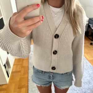 Beige kofta  - Beige v-ringad kofta från HM. Perfekt att sätta på sig på kvällen på sommaren och passar till det mesta. Storlek xs men passar xs och s. 