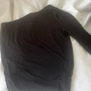 Tröja - Svart topp från GINA med en arm i strlk M, aldrig använd 