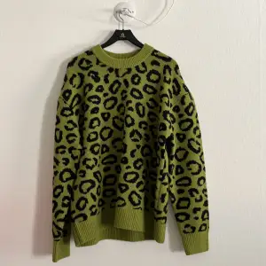 Stickad grön tröja med leopardmönster från H&M. Aldrig använd, prislapp kvar!