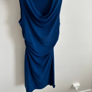 Blå klänning - Supersnygg blå klänning som sitter jättefint. Oanvänd. 