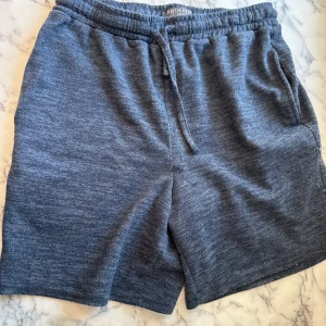 Blå pyjamas shorts  - Ett par blåa pyjamas shorts från primark. Shortsen har ett mjukt material och är stretchiga vilket ökar sömnkvaliten enormt för de som har svårt att sova. Shortsen har endast används fåtalet gånger vilket bevarat deras nya utseende och känsla. 