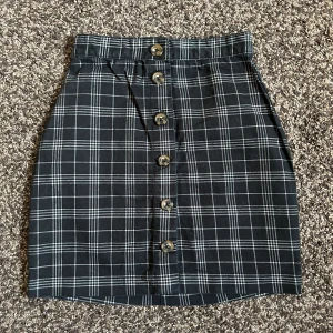 Rutig kjol med knappar - Använda 3 gånger, knappar så man kan öppna den helt och sätta på sig