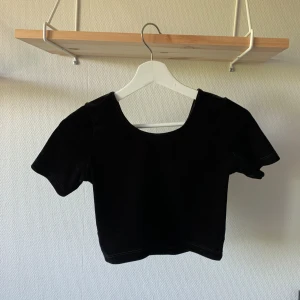 Svart croptop - Svart croptop i mjukt velour, djup halsringning och likadant i ryggen! sitter som en smäck!