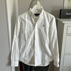 En vit Polo Ralph Lauren skjorta i felfritt skick! Storlek slim fit M passar dock mer som en slim fit S. Nypris runt 1700kr, säljes då den ej kommer till användning.