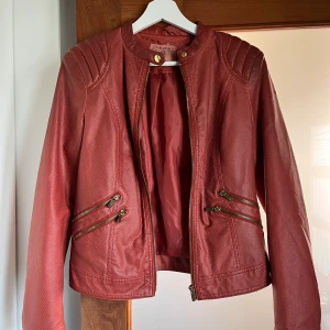 Röd skinnjacka  - Köpt på secondhand, använder inte längre. Rätt tunn och behaglig nu under sommarkvällarna 