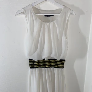 Lång klänning  - En vit lång klänning, som ny helt oanvänd.