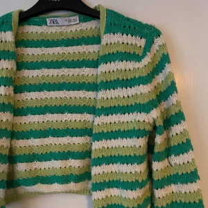 Stickad kofta från Zara - Hålstickad kofta från Zara. Köpt 2021, fint skick. Storlek S. Perfekt att ha över en vit klänning under en sommarkväll. Säljer för 150:-. Köparen betalar ev frakt. Kan mötas upp i centrala Stockholm. 