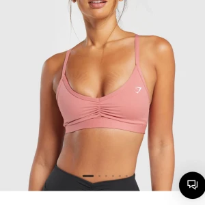 Gymshark sportbh - Ruched strappy sports bra från gymshark i färgen pink. Oanvänd, har prislapp kvar och ligger kvar i oöppnat paket. Originalpris 349kr, pris kan diskuteras☺️