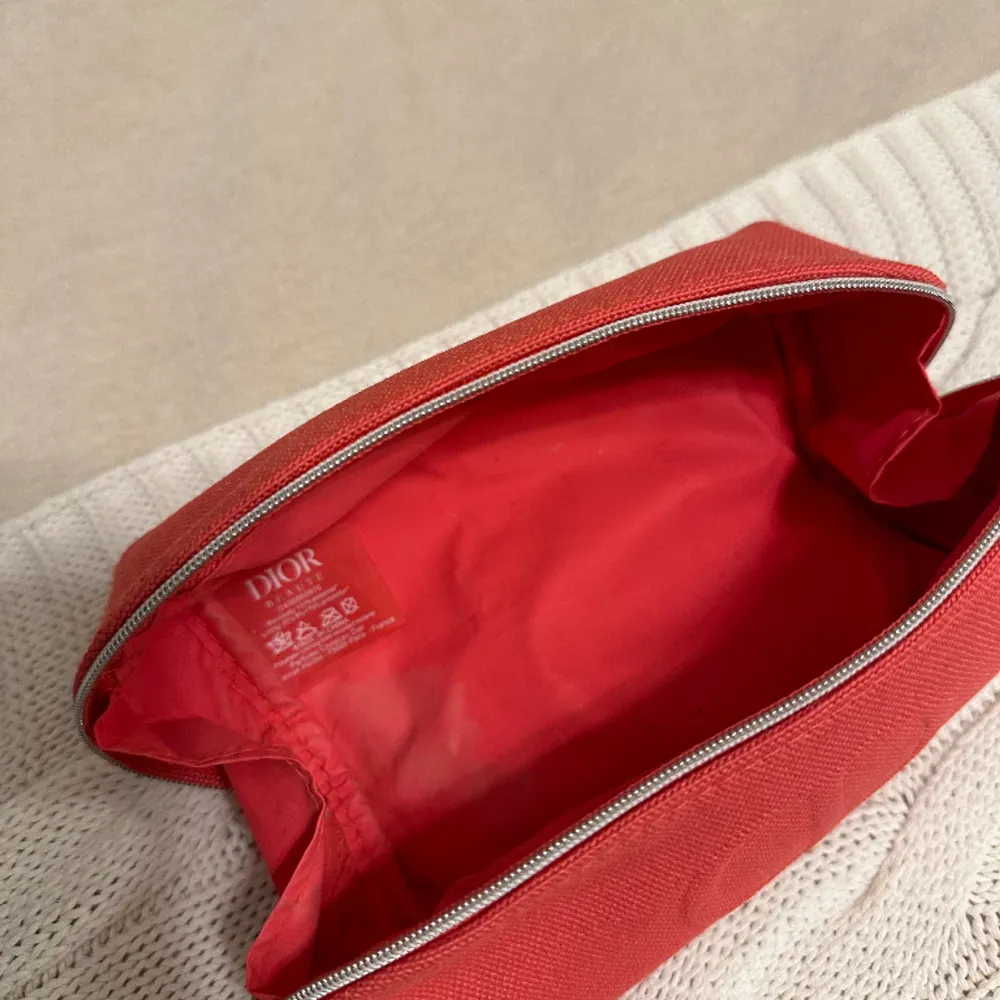Rosa / röd sminkväska från Dior. Fått den vid köp av Dior produkter på Selfridges I London. . Accessoarer.