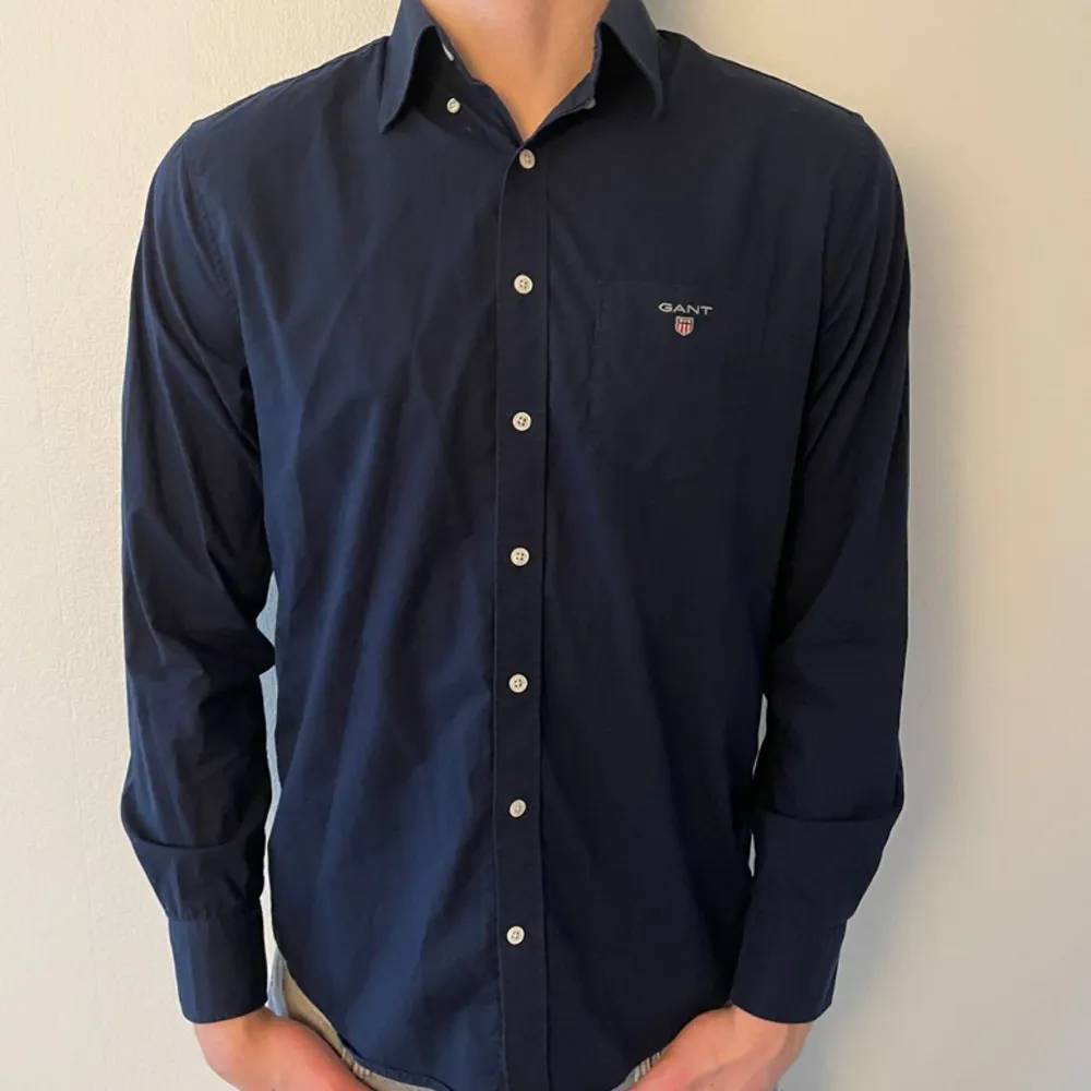 Gant Skjorta i färgen marinblå | Modellen är 192 cm och väger 87 Kg och bär storlek M (passar L) | Kontakta oss för mer info 🥂. Skjortor.