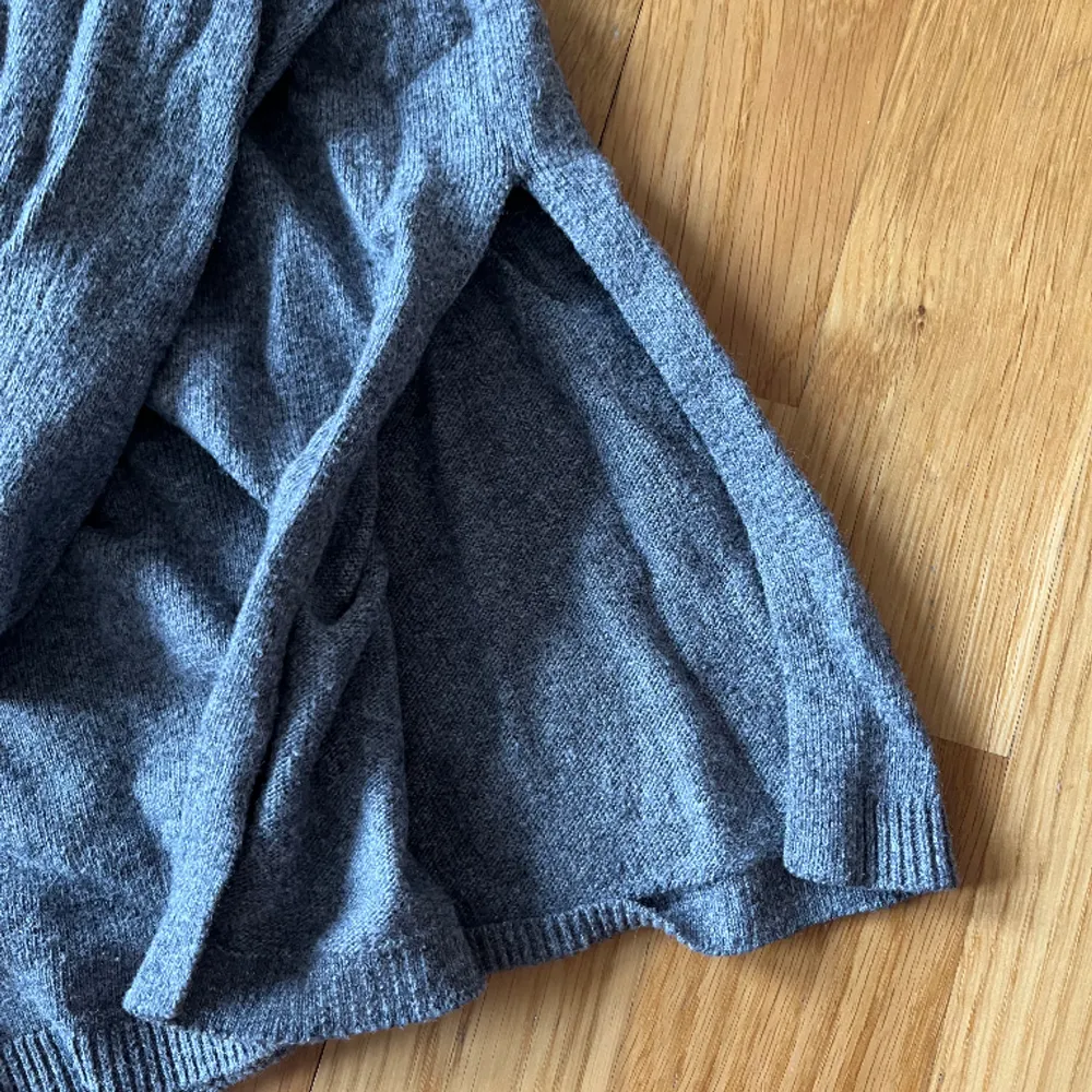 En grå stickad tunn tröja med en slit på bägge sidorna vid slutet väldigt uv ringad och även halvt kort i armarna, aldrig använt . Tröjor & Koftor.