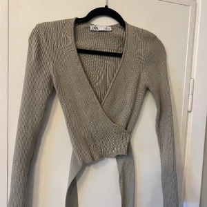 Khakifärgad topp - En khakifärgad fint stickad tröja från Zara. Tröjan är croppad och knyts runt midjan. I storlek S. Har använd ganska många gånger men är i fint skick!