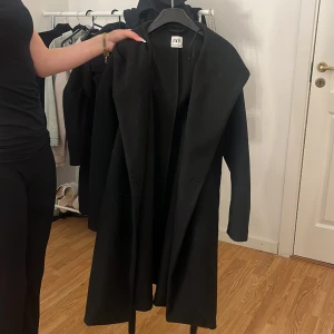 En svart kappa - Svart kappa i storlek Xs från Zara, är i bra skick bara använda två gånger  