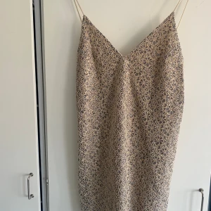 Klänning Zara S - Beige blå sommarklänning med virkade blommor, djup urringning i ryggen och tunna axelband.  Storlek S från Zara, plaggets hela längd inkl axelband är ca 79cm Föer bilder fås i chatten!