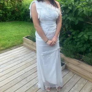 Balklänning - Jättefin glitter vit balklänning som har använts för en gång, kommer inte användas igen och därför säljs. Inga defekter eller något fel finns på klänningen. Köptes för 899kr och därför säljs för 499