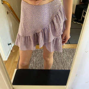 Lila omlottkjol - Superhärlig lila omlottkjol med blommor. Man knyter den runt sig så den är lätt att justera! 💞Kommer inte till användning • Använd gärna köp nu🌟 