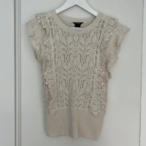 Lindex stickad spetstopp volang S - Superfin offwhite stickad spetstopp med volangärm från Lindex. Toppfint skick, nästan oanvänd. Storlek S. 50% viskos, 50% akryl.