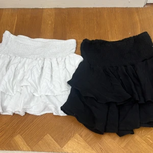 Volangkjolar - En svart och en vit volang kjol, ganska nya, okänt märke, storlek S på båda men de stretchar ut så S/M, 50kr för en 100kr för båda 