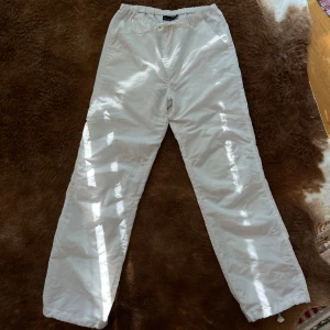Parachute pants - Tuffa brallor i vitt, inga fläckar. De perfekta sommarbyxorna! Dragsko längst ned på benen. Storlek S men passar även större storlekar, sitter oversize på mig som är S/M. 