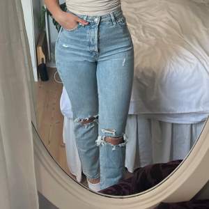 Blå jeans men hål på knäna från H&M storlek 34. Knappar som knäppning i använt men gott skick 