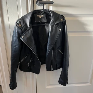 Skinnjacka  - Beg skinnjacka i fuskläder, använd men i fint skick, dock en fläck se bild, har inte prövat rengöra/ta bort. Köparen betalar frakt. 