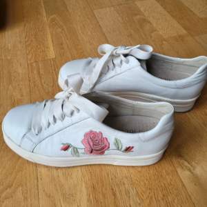 Vita sneakers med en blomma.  Sidenband. Storlek 38.