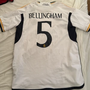 Oanvänd fotbollströja - Real Madrid 23/24 - Oanvänd Real madrid tröja säsong 23/24. Nummer 5 Jude Bellingham på ryggen. Storlek S.  Köparen står för frakten. Kan mötas upp i stockholms området