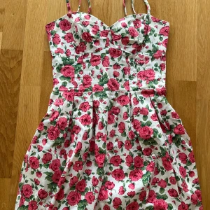 Sommar Klänning - Kort klänning med zip uppifrån ryggen. Justerbar vid snörerna vid axlarna. 