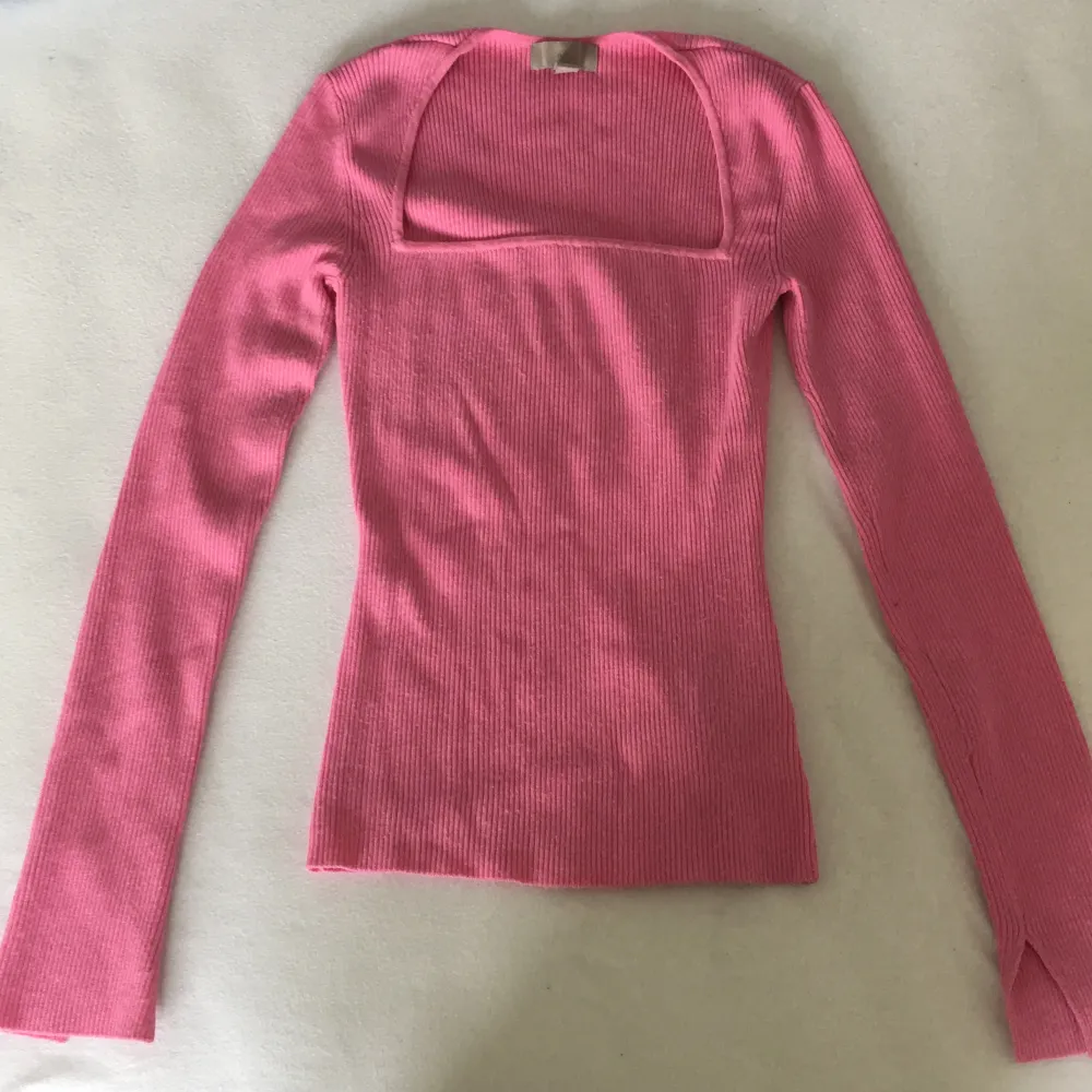 Långärmad rosa tröja från H&M. Super söt och jättebra passform men färgen passar mig inte. Nyskick bara använd en gång. Har fina slitsar vid ärmarna. Kan fraktas om köparen betalar för frakten.. Tröjor & Koftor.