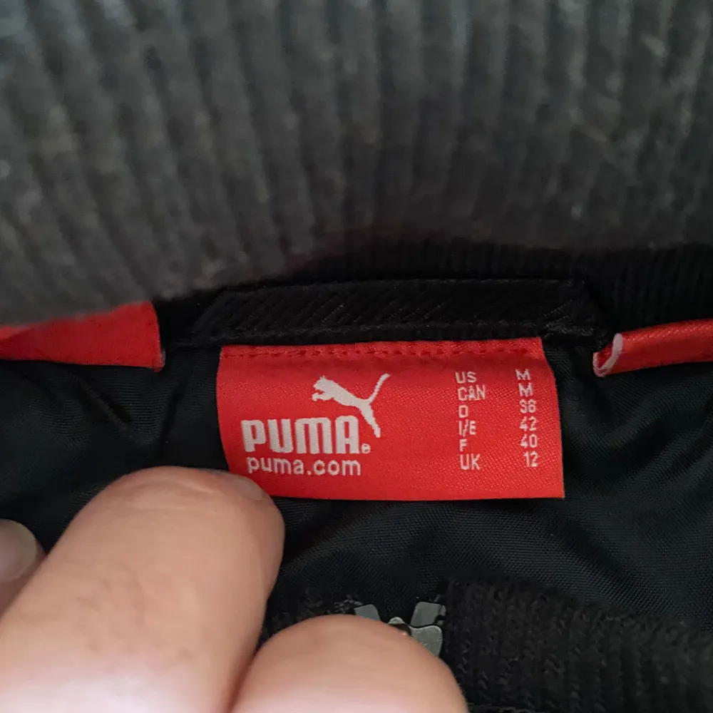 Svart Puma Ferrari jacka i cool racing stil med många detaljer. Lite slitage vid kajen annars i mycket bra skick!. Jackor.