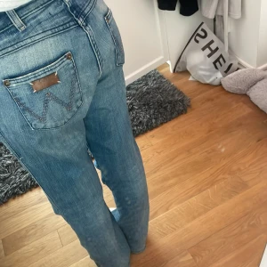 Wrangler byxor - Wrangler byxor med lite slitningar längst ner vid fötterna och innrelåren. Har ett band i midjan som man kan dra åt om byxorna är för stora, annars går de bara att dra ut. Storlek W30 L36. Passar på folk som är S/M. Skriv privat för bilder och frågor
